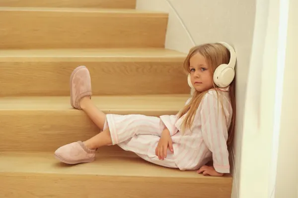 Girl in pajamas and headphones on the stairs, commercial photography by Photoholic, Monsey NY