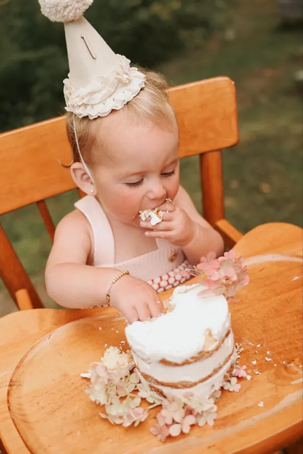 Baby smashing a cake on an orange chair outdoors, outdoor photography by Photoholic, Rockland County NY